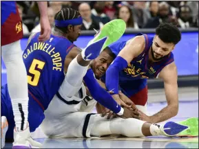  ?? BRANDON DILL — THE ASSOCIATED PRESS ?? Grizzlies forward Xavier Tillman, center, struggles for control of the ball against Nuggets guards Kentavious Caldwell- Pope ( 5) and Jamal Murray ( 27) during the second half of a game Saturday in Memphis, Tenn.