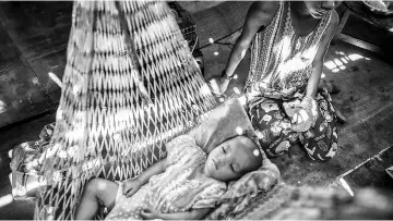  ??  ?? Hteik (right) babysittin­g his sister at their home in the Myaung Dakar industrial zone in Hmawbi Township in Yangon. — AFP photo