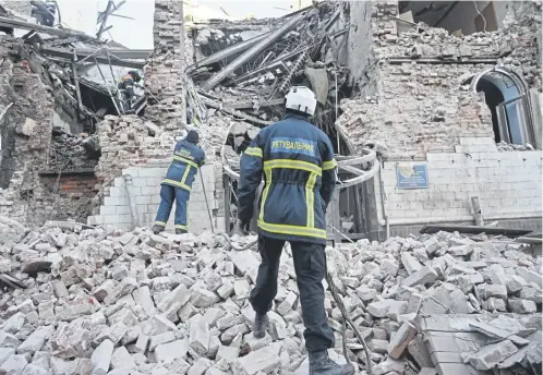  ?? ?? Ukrainian rescuers clear debris at the site of a missile attack in Kharkiv in which at least 17 people were injured