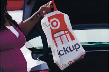  ?? ROGELIO V. SOLIS — THE ASSOCIATED PRESS ?? A Target employee places a purchase into the trunk of a customer’s car. After a weak start to the holiday season for many mall-based retailers, the companies are making their final push in the final days before and the week after Christmas.