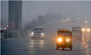  ??  ?? Traffic moves on a foggy morning in New Delhi on Monday. —