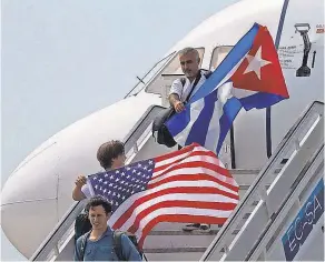  ??  ?? Passengers wave American and Cuban flags as they leave a JetBlue flight. JetBlue says it’s committed to serving Cuba for the long haul. RAMON ESPINOSA/AP