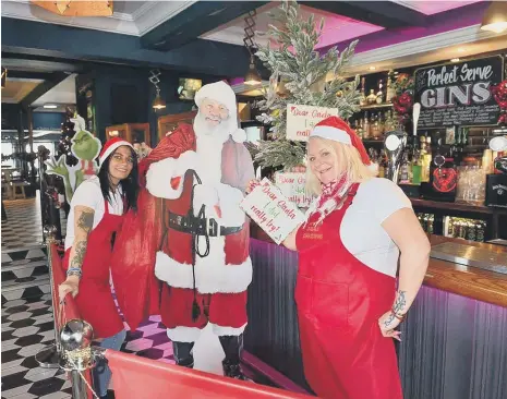  ??  ?? Vesta Tilleys bar staff Paula Leighton, left, and Anthea Perry decorate the Christmas Tree. Picture by FRANK REID