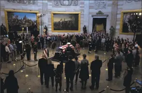  ?? Jose Luis Magana / Associated Press ?? Visitors pay their respects at the flag-draped casket of former President George H.W. Bush, as he lies in state in the Capitol Rotunda in Washington on Tuesday.