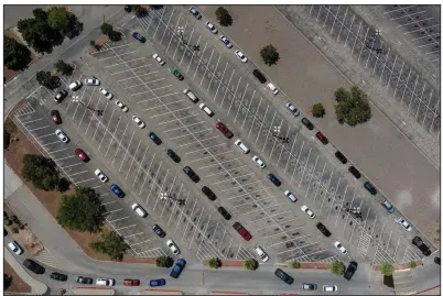  ?? (The New York Times/Cengiz Yar) ?? Vehicles snake through a parking lot Monday as people wait at a drive-thru testing site on a community college campus in El Paso,
Texas.