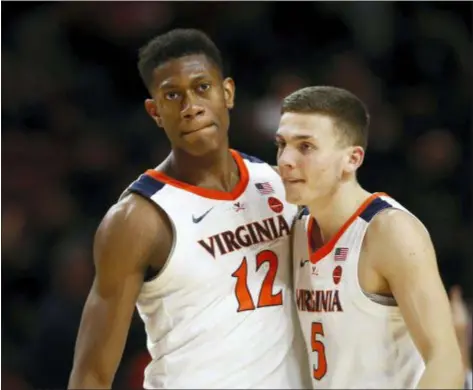  ?? PATRICK SEMANSKY — THE ASSOCIATED PRESS ?? Virginia guards De’Andre Hunter, left, and Kyle Guy embrace in the final moments of a game against Maryland Wednesday night. Virginia claimed a 76-71 victory.