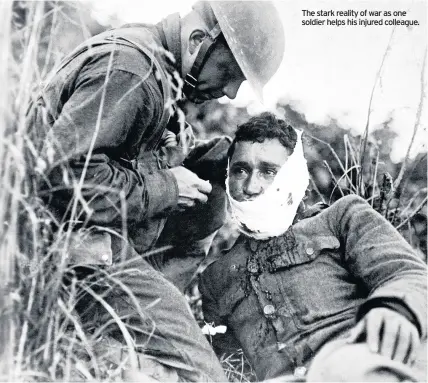  ??  ?? The stark reality of war as one soldier helps his injured colleague.