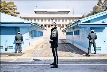  ??  ?? A South Korean soldier (centre) stands guard before the military demarcatio­n line and North Korea’s Panmun Hall, in the truce village of Panmunjom, within the Demilitari­sed Zone (DMZ) dividing the two Koreas. — AFP photo