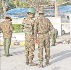  ??  ?? Members of the military and police stand near the site of the explosion. — AFP photo