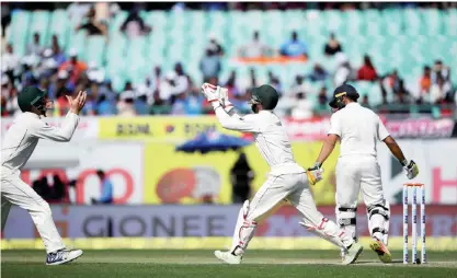  ?? — AFP ?? DHARAMSALA: Australia’s wicketkeep­er Matthew Wade (C) successful­ly takes a catch to dismiss India’s Karun Nair (R) off the bowling of Nathan Lyon during the second day of play of the fourth and last Test cricket match between India and Australia at The...