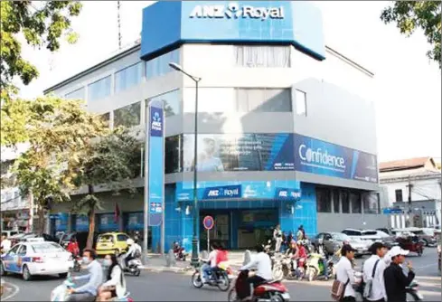  ?? VIREAK MAI ?? Afternoon traffic passes an ANZ Royal Bank branch in Phnom Penh’s Daun Penh district in late March.