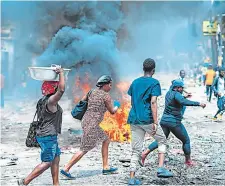  ?? ?? Varias personas abandonan el lugar donde se realiza una protesta en Puerto Príncipe (Haití).