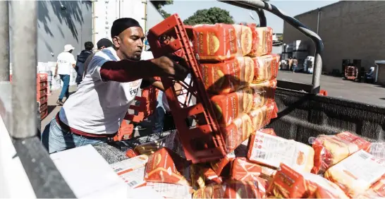  ?? Pictures: AFP ?? BREAD OF LIFE. A volunteer from Muslims for Humanity offloads a crate of bread at the NMJ Islamic Centre to distribute to members of the public in Durban.