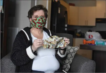  ?? NEWS PHOTO MO CRANKER ?? Hatter Pam Robertson-Rivet shows off a couple of masks that will be donated to The Mustard Seed while in her apartment Saturday.