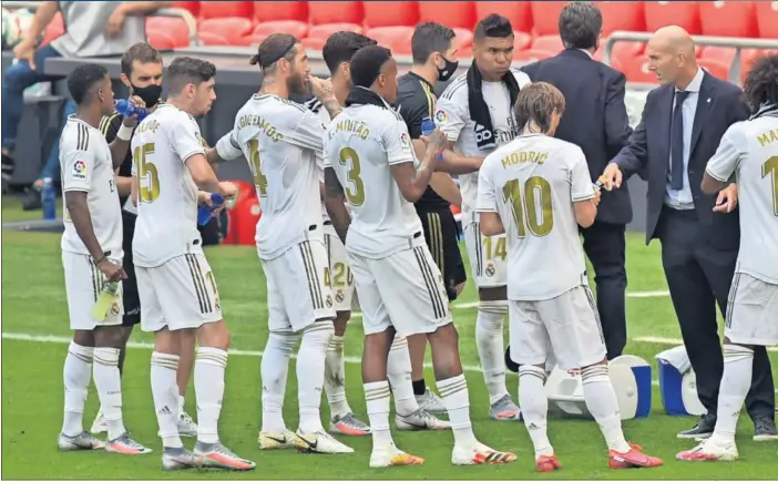  ??  ?? En la imagen se contempla, en San Mamés, uno de los tiempos de hidratació­n, que aprovechó Zidane para dar instruccio­nes a sus jugadores. Todos le escuchan atentos.