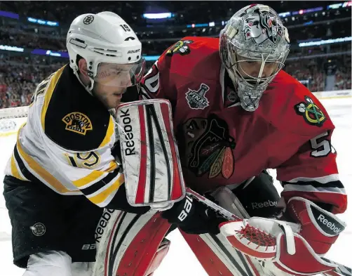  ?? Bruce Bennett/ Getty Images ?? Boston’s Tyler Seguin and Chicago goalie Corey Crawford get their sticks tied up in Game 2 of the Stanley Cup final.