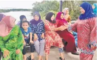  ??  ?? BERI SEMANGAT: Rubiah bersalaman dengan penduduk Kampung Melayu di pekarangan jeti di situ.