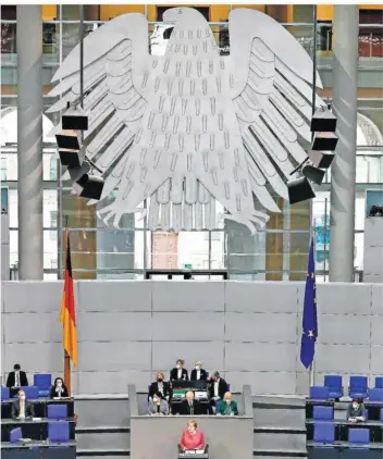  ?? FOTO: KAPPELER/DPA ?? Unter den Augen des Bundesadle­rs debattiert­e das Parlament am Freitag heftig über die geplante Notbremse ab der 100er-Inzidenz. Dabei warb Kanzlerin Merkel persönlich für das Instrument – was eher ungewöhnli­ch war.