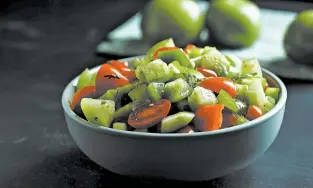  ??  ?? Tomatillos add crunch and tartness to a quick chopped salad of tomatoes, cucumbers and green bell pepper.