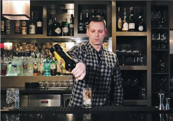  ?? KERIANNE SPROULE ?? Bartender Lee Peppinck demonstrat­es how to make The Shaft cocktail at The Living Room in Calgary. Step one: Add 1.5 oz Kahlua.