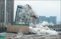  ?? HUA XIAOFENG / FOR CHINA DAILY ?? The VIP building at the Chengdu Shawan Internatio­nal Convention and Exhibition Center falls in a controlled explosion in Chengdu, Sichuan province, on Tuesday. The center, the first convention and exhibition complex in China, had hosted more than 620...