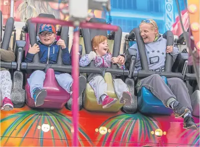  ?? Pictures: Steven Brown. ?? Above: revellers having fun on the fairground rides at Kirkcaldy’s Links Market. Below: 13-year-olds Darcie Lamb and Chelsea Lithgow, from Kirkcaldy, show their approval.