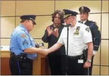  ?? EVAN BRANDT — DIGITAL FIRST MEDIA ?? After presenting him with his retirement badge, Pottstown police Chief Richard Drumheller, right, congratula­tes Cpl. Charles McClincy, who is retiring after 44 years of service to the department.