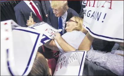  ?? JOHN AMIS / ASSOCIATED PRESS ?? Republican presidenti­al candidate Donald Trump stops to pose for a selfie with Wanda Hughes of McDonough at a campaign rally of 7,700 people in Norcross on Saturday.