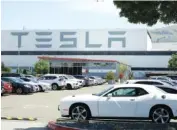  ?? AP PHOTO/BEN MARGOT ?? Vehicles are parked at the Tesla car plant Monday in Fremont, Calif. The parking lot was nearly full at the electric car factory.
