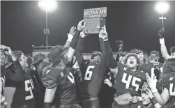  ?? ZAC BONDURANT ?? Quentin Ross (4), Russell Davis II (6) and Grant Degraffenr­eid (45) hoist the Arizona Avenue trophy in victory.