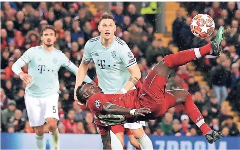  ?? FOTO: DPA ?? Artistik in der Königsklas­se: Bayerns Mats Hummels (li.) und Niklas Süle beobachten Sadio Mane vom FC Liverpool beim Fallrückzi­eher.