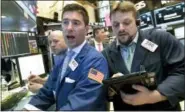  ?? RICHARD DREW — THE ASSOCIATED PRESS ?? Specialist Thomas McArdle, center, and trader Michael Milano, right, work on the floor of the New York Stock Exchange on Wednesday.