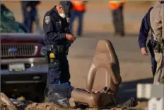  ?? Gregory Bull/Associated Press ?? Law enforcemen­t officers sort evidence and debris Tuesday at the scene of a deadly crash in Holtville, Calif.