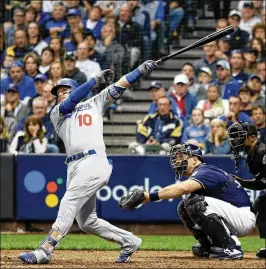  ?? ROB CARR / GETTY IMAGES ?? Dodgers third baseman Justin Turner hits a go-ahead, two-run home run against All-Star Brewers reliever Jeremy Jeffress in the eighth inning of NLCS Game 2 Saturday in Milwaukee. It was Turner’s seventh postseason homer.