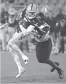  ?? ROB SCHUMACHER/AZCENTRAL SPORTS ?? Arizona State quarterbac­k Manny Wilkins tries to avoid a tackle attempt by San Diego State linebacker Jay Henderson at Sun Devil Stadium in Tempe on Saturday night.