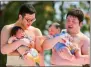  ?? PHOTO: AP ?? College sumo wrestlers hold babies in the Naki Sumo Crying Baby Festival at Sensoji Buddhist temple in Tokyo on April 26, 2014.
