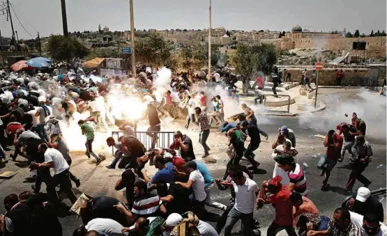  ?? Ammar Awad/Reuters ?? Manifestan­tes palestinos entram em confronto com policiais israelense­s em Jerusalém após Israel proibir entrada de homens com menos de 50 anos