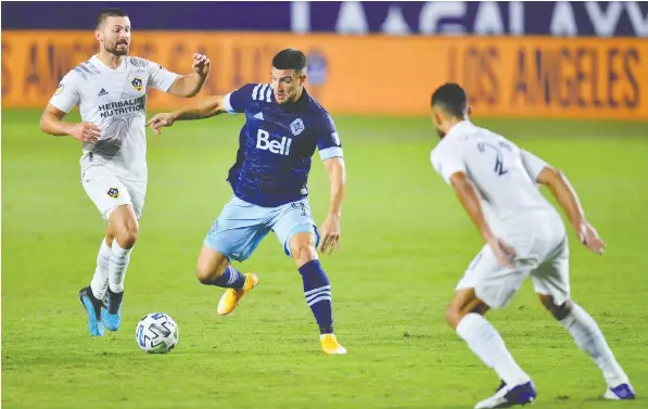  ?? GARY A. VASQUEZ/USA TODAY SPORTS FILES ?? Striker Lucas Cavallini, here playing the ball between a pair of L.A. Galaxy players last season, led the team with just six goals in 2020 as the team struggled offensivel­y — hence the Whitecaps' search for a creative, attacking midfielder to energize the attack.