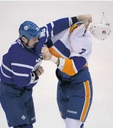  ?? PETER J. THOMPSON/ POSTMEDIA NEWS ?? Toronto’s Frazer McLaren punches the Islanders’ Matt Carkner on Thursday night in Toronto. The Islanders won the game 5-3.