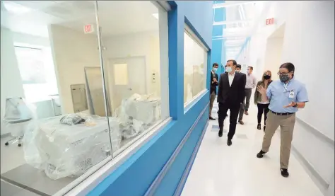  ?? Matthew Brown / Hearst Connecticu­t Media ?? Emmett Higgins, VP of Laboratory Operations, at right, leads U.S. Sen. Chris Murphy, along with elected officials, on a tour of Sema4’s new facility in Stamford on Friday. Below, Connecticu­t state Rep. Matt Blumenthal, left, looks at an Agilent NGS Workstatio­n during the tour.