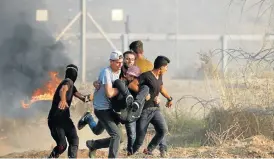  ?? /Reuters ?? Quick response: Palestinia­n demonstrat­ors carry a wounded man during an anti-Israel protest at the border fence between Israel and Gaza, east of Gaza City, on Friday.