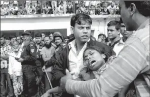  ?? AP/HASAN RAZA ?? People console a woman Sunday whose relative was killed in a fire at a garment factory Saturday outside Dhaka, Bangladesh.