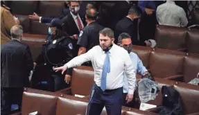  ?? J. SCOTT APPLEWHITE/AP ?? Rep. Ruben Gallego, D-Ariz., and other lawmakers evacuate the House chamber after protesters broke into the Capitol on Wednesday. Police told lawmakers to grab gas masks and rushed them to a secure location.