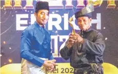  ?? ?? Aziz (right) receiving the Guru Bodybuildi­ng of the Year Award at the Enrich Sports Award 2024 in Selangor recently.