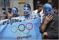  ?? FILE PHOTO: TATAN SYUFLANA — THE ASSOCIATED PRESS ?? Student activists wear masks with the colors of the proindepen­dence East Turkistan flag during a rally to protest the Beijing 2022Winter Olympic Games, outside the Chinese Embassy in Jakarta, Indonesia, Friday, Jan. 14, 2022.