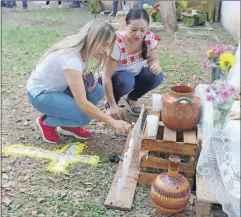  ?? ?? Sobre estas líneas, María Pérez Torres y Lidieth Serrato Salas encienden las velas de su altar en Uniprint; a la derecha, detalle de los alimentos colocados por los colaborado­res de Dypaq