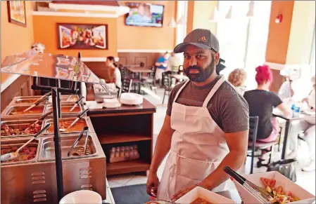  ??  ?? Owner Gurpreet Singh stands at the daily lunch buffet at The Royal Punjabi, a new Indian and chicken wings restaurant on Main Street in Norwich.