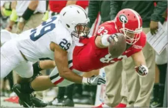  ?? MARK WALLHEISER — THE ASSOCIATED PRESS ?? Georgia tight end Jeb Blazevich dives for extra yardage against Penn State cornerback John Reid during the first half of the TaxSlayer Bowl in Jacksonvil­le, Fla., Saturday.