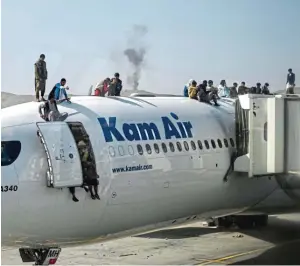  ??  ?? Verzweifel­te Afghanen versuchen in Kabul ein Flugzeug zu besteigen, um fliehen zu können.