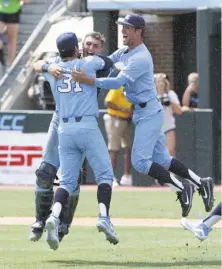  ?? Gerry Broome / Associated Press ?? North Carolina pitcher Josh Hiatt (31) hugs catcher Brandon Martorano as infielder Dallas Tessar joins the celebratio­n.